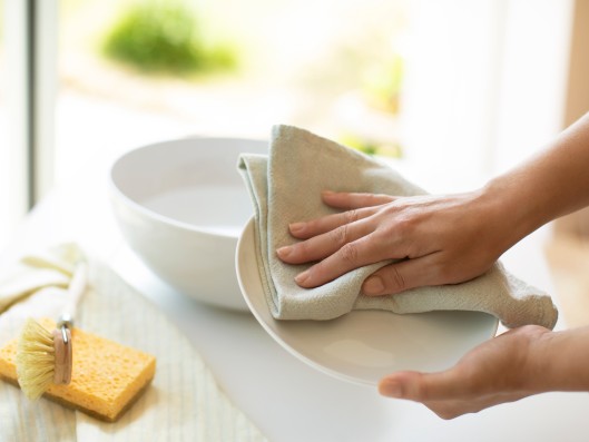 A plate is dried with a cloth in the kitchen
