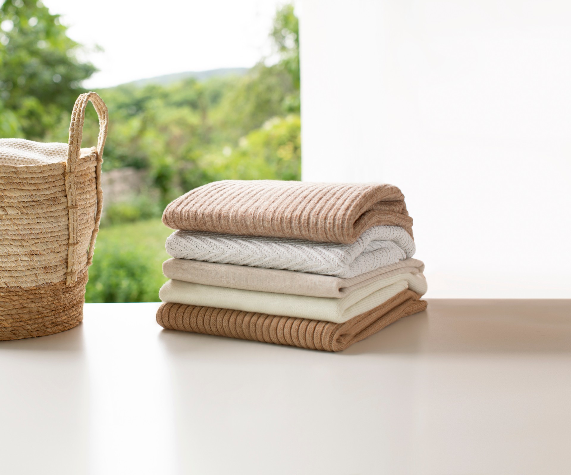 Stacked towels lying next to a basket with laundry